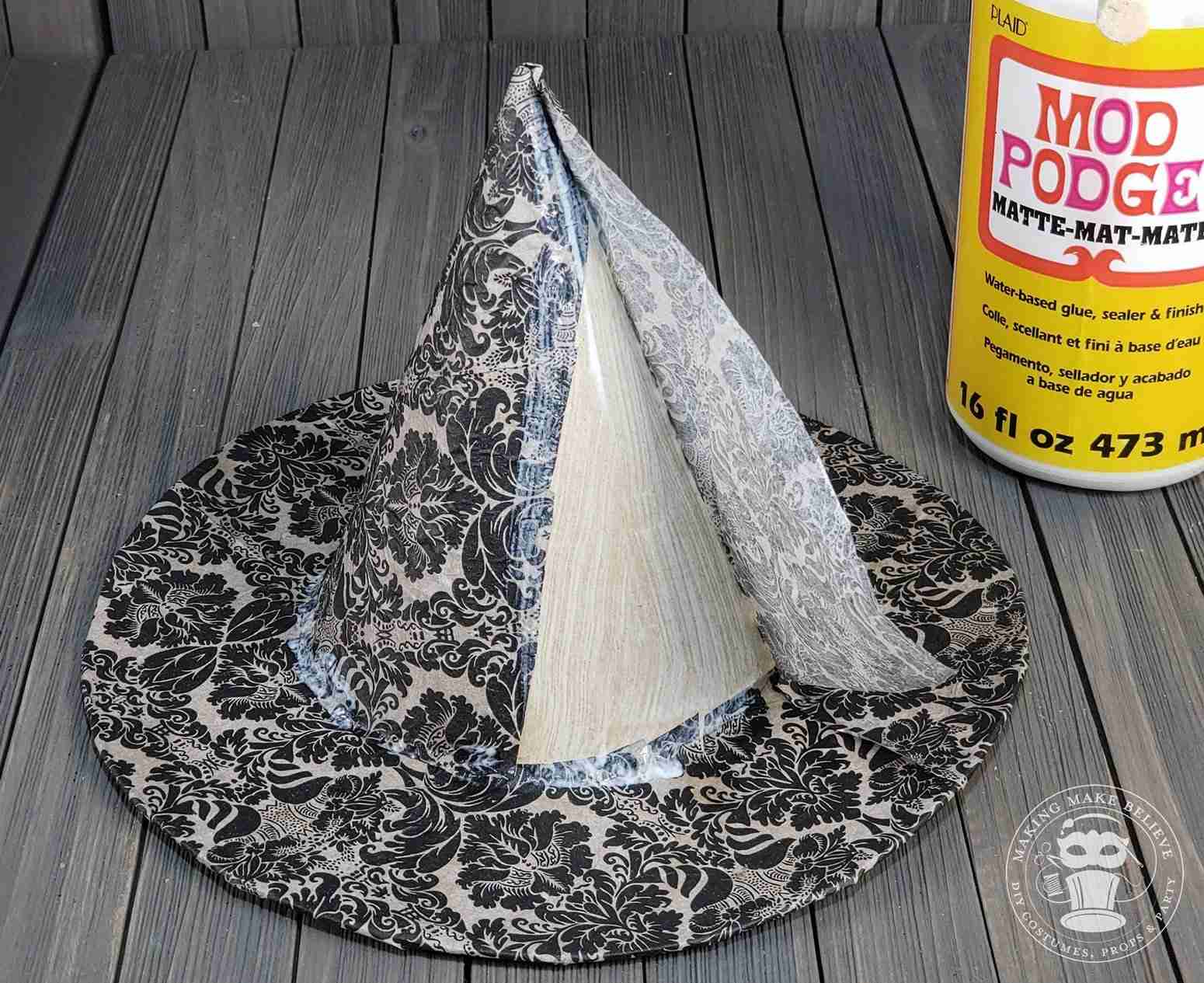 Continue to attach napkin around hat
