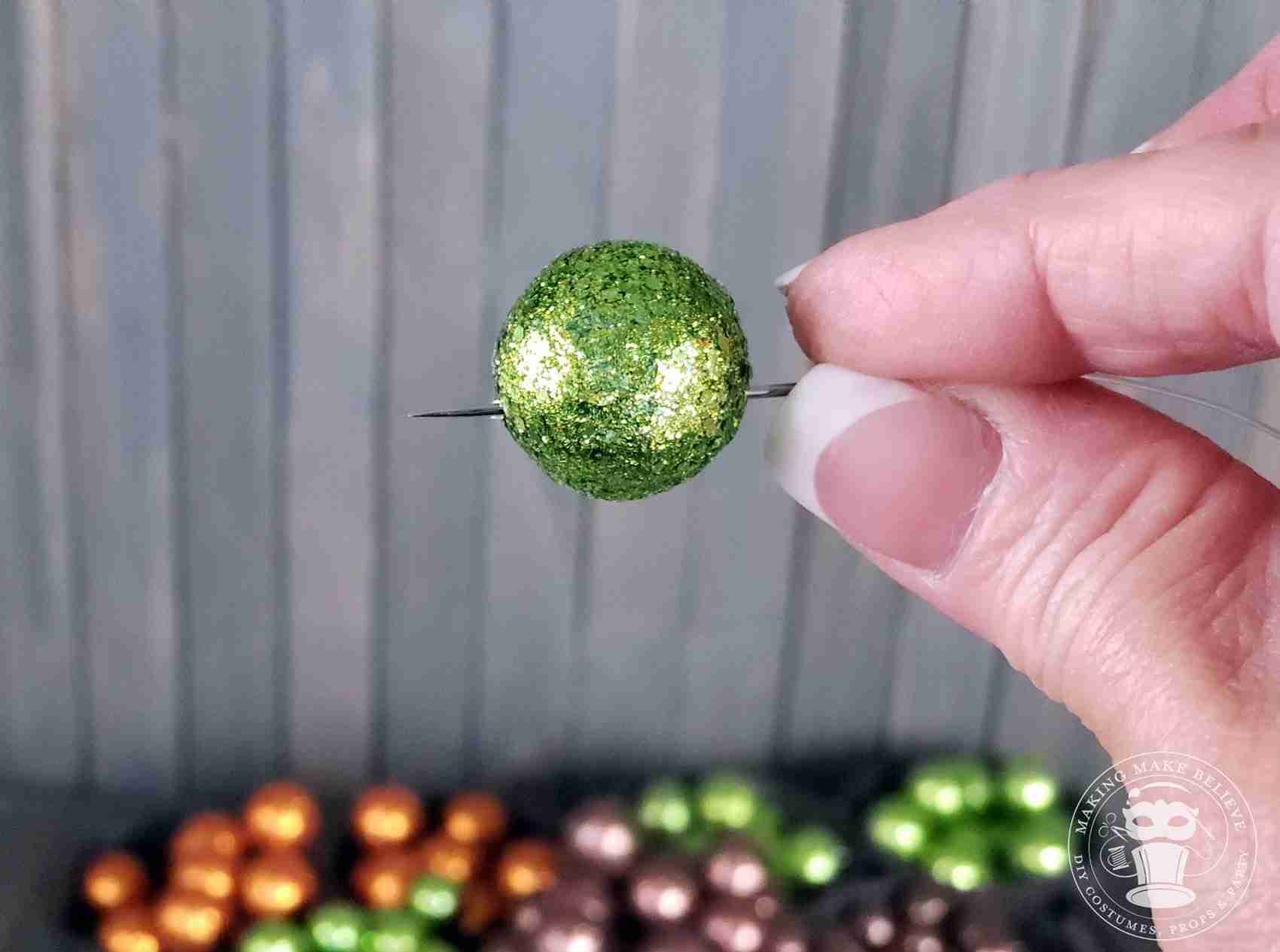 Thread glitter balls onto monofilament