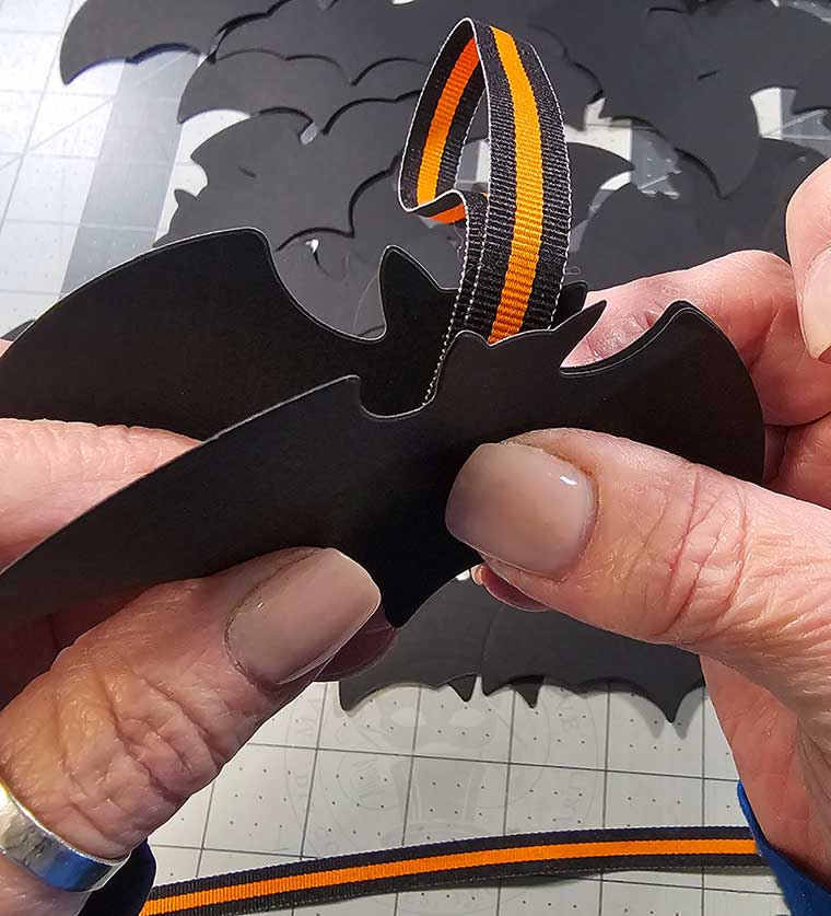 Lay a second bat cutout on top of ribbon