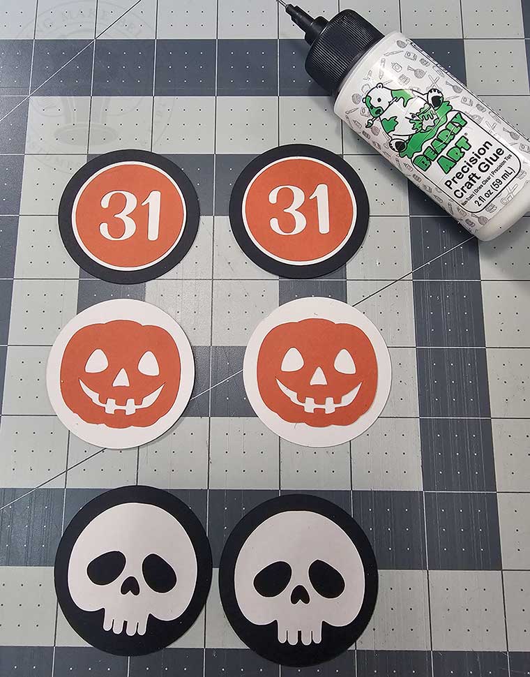 Glue together Halloween cupcake wrapper medallions