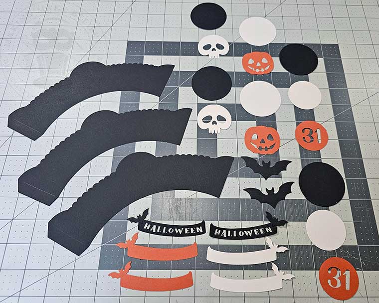 Paper piece cut out to make DIY Halloween cupcake wrappers and picks