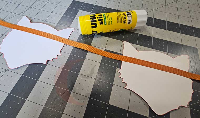 Lay ribbon onto cat faces and glue